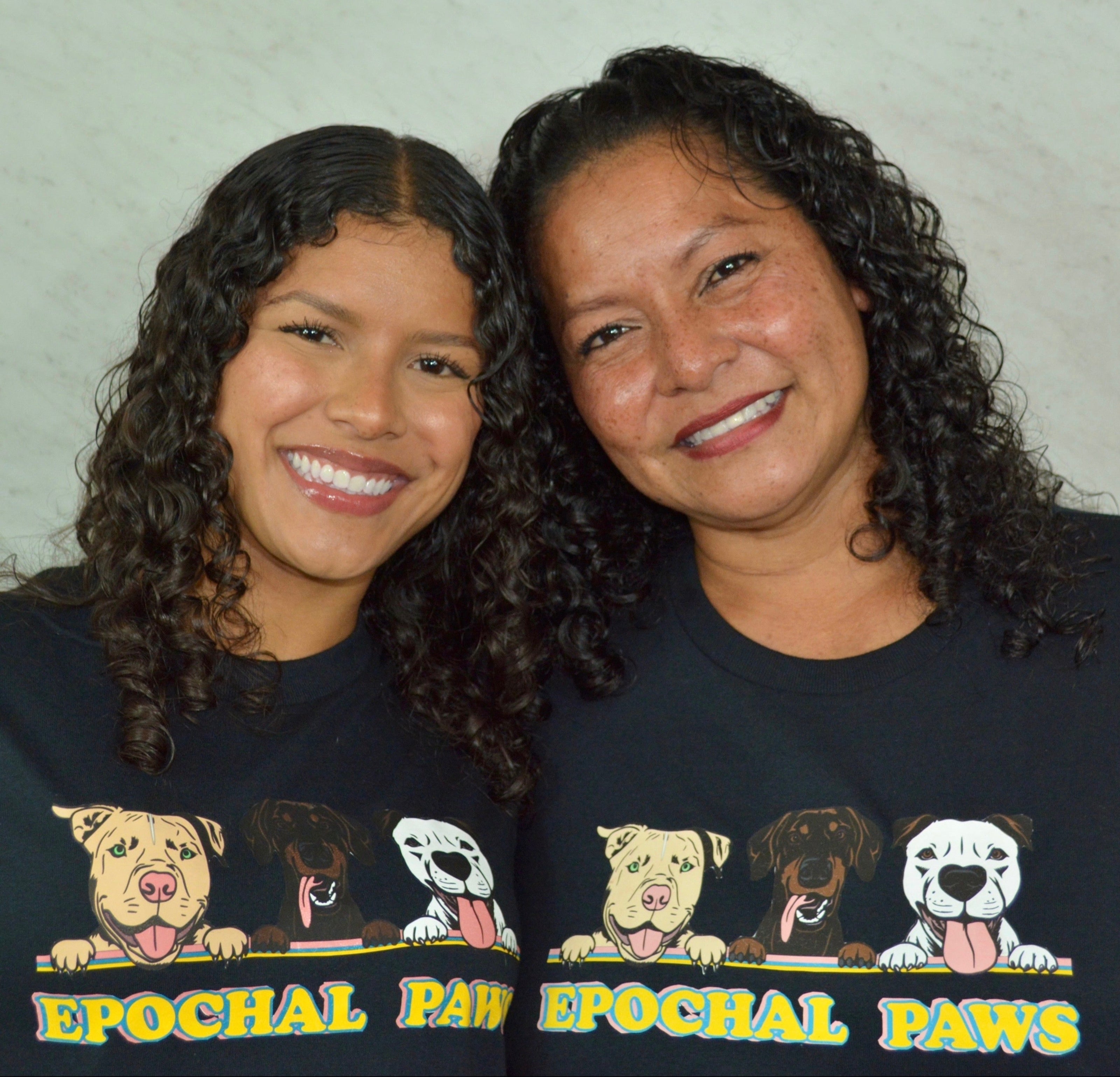 Daughter and mom smiling in black shirts with a grey background